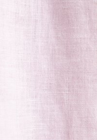 Tissu rose clair texturé avec un motif tissé visible et de légères rides naturelles.