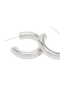 Srebrne kolczyki w kształcie kół z gładką, błyszczącą powierzchnią. Okrągły kształt z delikatnym skrętem, z cienkim prętem do mocowania.
