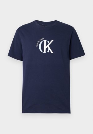 Laivastonsininen puuvillainen t-paita, jossa on lyhyet hihat ja pyöreä pääntie. Edessä valkoinen "CK"-logo ja "Calvin Klein" -teksti.