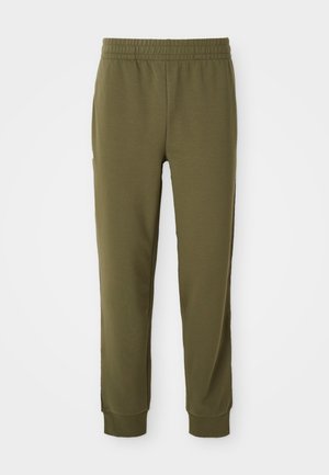Olivenfargede joggebukser laget av mykt stoff, med elastisk midje, innsnevrede ben og ribbede mansjetter samt sidelommer.