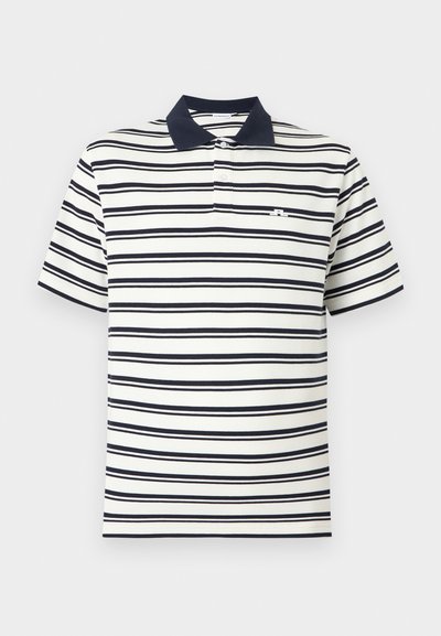 Λευκό πόλο μπλουζάκι με κοντά μανίκια και μαύρες οριζόντιες ρίγες, με μαύρο γιακά, δύο λευκά κουμπιά και μικρό λογότυπο στο στήθος.