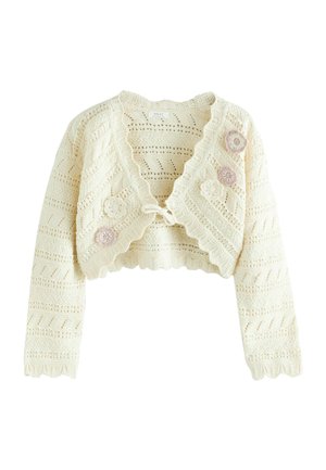 Cremefarbene gehäkelte Kurzjacke mit gewellten Rändern, vorderer Schnürung und drei pastellfarbenen Blumenapplikationen auf einer Seite.