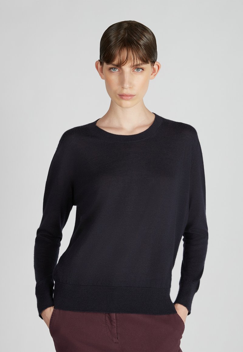 Pull marin en tricot doux, avec un col rond, des manches longues et un ourlet côtelé. Design simple sans motifs ni embellissements.