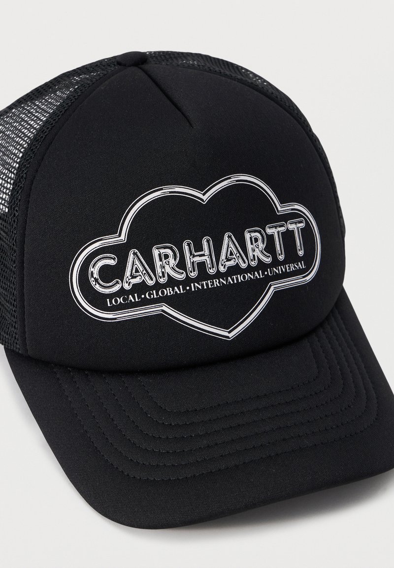 Casquette trucker en mesh noir avec le logo "CARHARTT" à l'intérieur d'un contour en forme de cœur et les mots "LOCAL • GLOBAL • INTERNATIONAL • UNIVERSAL" en dessous.