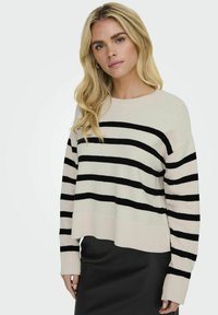 Gestreifter Pullover in Creme und Schwarz, verfügt über einen gerippten Halsausschnitt und Bündchen, leicht verkürztes Design mit entspannter Passform und weicher Textur.