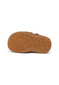 Suela de zapato de goma marrón con patrones de ondas texturizados y "WODEN" grabado. Presenta bordes estriados para mayor agarre y estabilidad.
