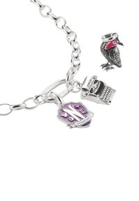 Silberarmband mit Anhänger: ein lilafarbener Schild, eine Schreibmaschinenfigur und ein schwarzer Vogel mit roten Akzenten und geschliffenen Augen.