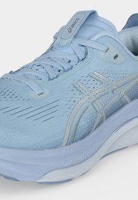 Φωτεινό γαλάζιο παπούτσι για τρέξιμο Asics με επάνω μέρος από δίχτυ, λογότυπο στη γλώσσα, κορδόνια και ενδιάμεση σόλα με απορρόφηση κραδασμών FF Blast Max.