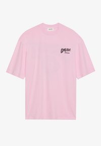 Pink cotton t-shirt with short sleeves, features a graphic print reading "GROOVE" in black on the left chest area. Simple design, crew neck.
