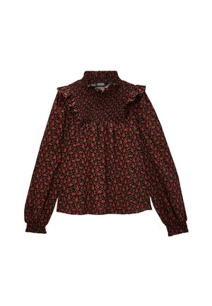 Blouse noire avec un motif floral rouge et vert. Elle a un col volanté, un corsage smocké et des manches longues avec des poignets élastiques.
