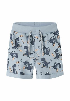 Lichtblauwe kinderbroekjes met elastische tailleband en trekkoord, met speelse donkergrijze dinosaurussen die op scooters en skateboards rijden.