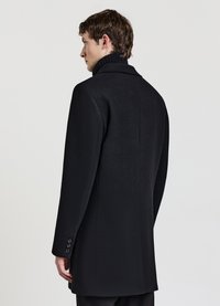 Schwarzer Wollmantel mit glatter Textur, langer Silhouette, umgeschlagenem Kragen und fünf Knöpfen am Ärmelabschluss. Die Rückseite verfügt über eine Mittelnaht.