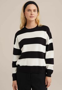 Mustvalge triibuline kudum, millel on ümar kaelus, mugav lõige ja pikad varrukad, millel on tekstuuriga pehme kangas.