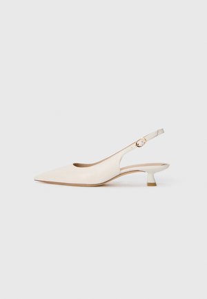 Cremefarbene Slingback-Schuhe mit spitzem Zehenbereich und niedrigem Kitten-Absatz sowie goldener Schnalle auf einfarbig weißem Hintergrund.