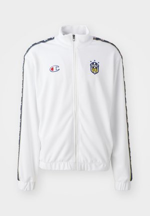 Hvid zip-up jakke med standkrave, med blåt og rødt broderet logo samt mønstrede sorte sidelister på ærmerne. Glat tekstur.