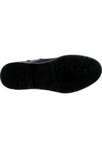 Suela de zapato de goma negra con un diseño texturizado que presenta patrones circulares y ovalados para mejorar la tracción. Diseño plano, material duradero y acabado mate.