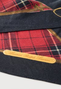 Κόκκινο και μαύρο καρό ύφασμα με απαλό υφή, διαθέτοντας σχέδιο με καφέ ξύλινο ραβδί στο κάτω μέρος και κίτρινες λεπτομέρειες.