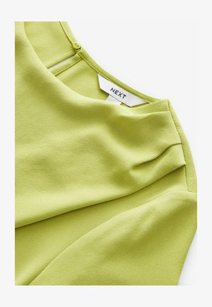 Bluză verde lime, made dintr-un material texturat și moale. Dispune de un decolteu rotund și o închidere cu un buton la spate, cu o cădere casuală. Eticheta mărcii este vizibilă.