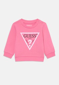 Rosa bomullströja för småbarn med lång ärm, ribbat ärmslut och rundad halsringning. Har en triangel-logotyp i svart med texten "GUESS U.S.A.".