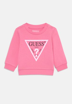 Hanorac din bumbac roz pentru copii, cu mâneci lungi, manșete ribbate și guler rotund. Prezintă un logo triunghiular negru cu textul „GUESS U.S.A.”.