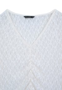 Top in pizzo bianco con design a V, caratterizzato da intricate fantasie floreali e un dettaglio drappeggiato sul davanti. Etichetta con scritto "CALLIOPE" taglia S.