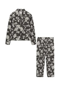 Veste noire et blanche à motifs floraux avec des boutons et deux poches, associée à un pantalon noir et blanc à motifs floraux assortis avec une taille élastique.