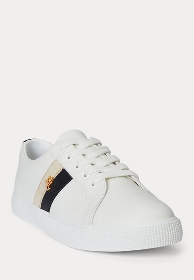 Baskets basses blanches avec lacets blancs, bandes latérales noires et beige, semelle blanche et petit logo doré sur la bande.