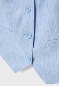 Tissu de blazer bleu clair avec de fines rayures verticales argentées, trois boutons bleus assortis et une petite poche fendue visible.