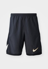 Shorts de sport noirs Nike avec une taille élastique, arborant un logo doré en bas à droite et des détails en mesh sur les côtés.