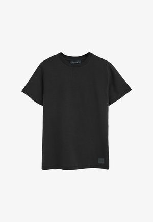 Camiseta negra de cuello redondo hecha de algodón, con mangas cortas, corte recto y una etiqueta con logo sutil en el dobladillo. Textura suave.