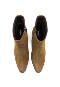 Ein Paar braune Wildleder-Stiefeletten mit seitlichen Reißverschlüssen, von oben auf einem weißen Hintergrund betrachtet.