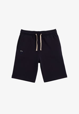 Pantalones cortos negros hasta la rodilla con cintura elástica, cordones blancos, bolsillos laterales y un pequeño logo en forma de escudo en el lado izquierdo.