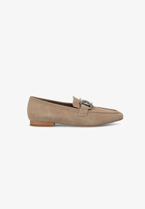 Beige Wildleder Slipper mit flachem Absatz, ausgestattet mit einer metallischen Schnallenakzentuierung und gesteppten Details im Obermaterial und im Zehenbereich.