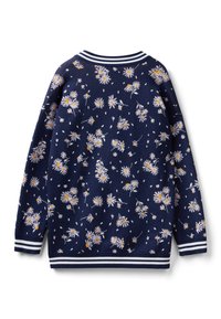 Marinblå stickad tröja med vit och gul blommönster, ribbad krage och manschetter har randiga detaljer vid nederkanten.