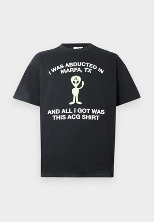 Schwarzes Baumwoll-T-Shirt mit weißem Text, der liest: "ICH WURDE IN MARFA, TX ENTFÜHRT UND DAS EINZIGE, WAS ICH BEKOMMEN HABE, IST DIESE ACG-HEMD" mit einer grünen Alien-Grafik.