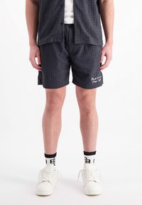 Donkergrijze shorts met een gestructureerd geometrisch patroon. De shorts hebben een elastische tailleband en subtiele geborduurde branding aan de zoom.