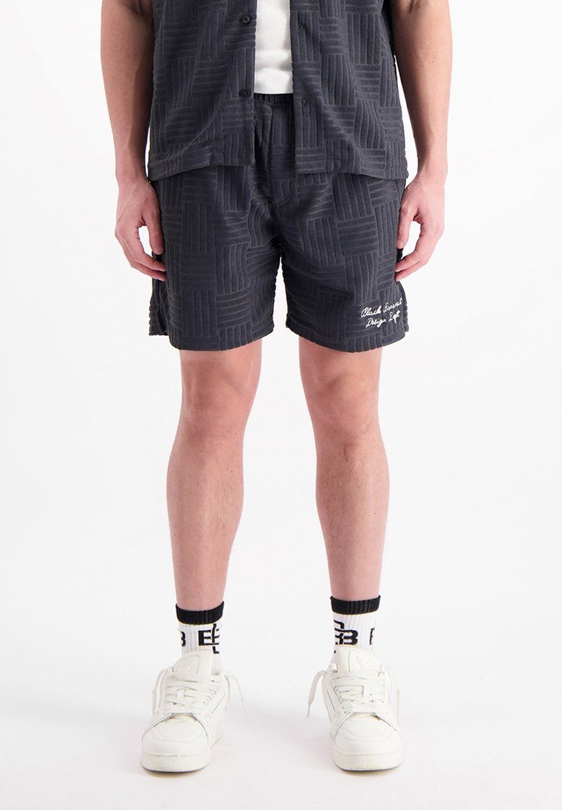 Donkergrijze shorts met een gestructureerd geometrisch patroon. De shorts hebben een elastische tailleband en subtiele geborduurde branding aan de zoom.