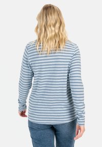 Lange mouw blauwe en witte gestreepte blouse, zachte stof, ronde halslijn, iets langere achterkant, gecombineerd met blauwe spijkerbroek.