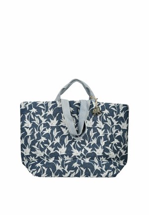 Niebieska torba materiałowa z białym kwiatowym wzorem, jasnoniebieskimi rączkami w kratę oraz małym zawieszonym przy uchwycie charmsem w kształcie słonia.