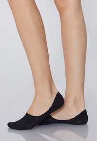 Chaussettes noires à coupe basse en tissu lisse, dotées d'un design sans couture et d'une texture douce, couvrant les orteils et les côtés des pieds.