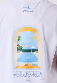 Chemise blanche avec une vue colorée depuis la fenêtre sur une piscine ensoleillée en bord de mer, un palmier, un yacht et des parasols, intitulée "Luxury Life Dreaming of Monaco."