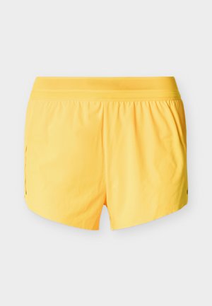 Gele shorts met een elastische tailleband, voorzien van een gaaslaag bovenaan en zijsplitten voor ventilatie. Soepele textuur en een lichtgewicht ontwerp.