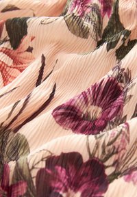 Blomster-mønstret stof i nuancer af pink og lilla, der har en letvægts, struktureret overflade med plisseringer og bladmotiver.