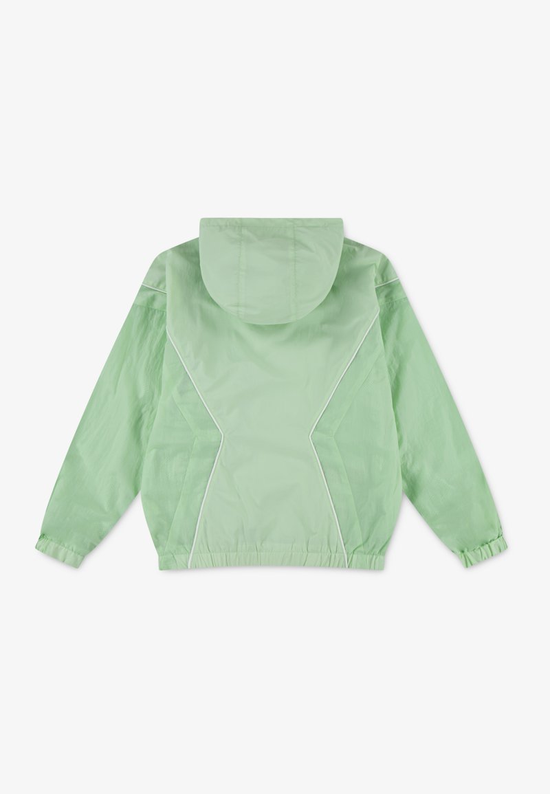 Giacca a vento verde chiaro, con cappuccio, polsini elasticizzati e dettagli in piping bianco. Texture liscia con vestibilità ampia.