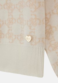 Maglione crema con un motivo testurizzato e tonale e bordo a coste. Include un piccolo logo a forma di cuore dorato con la scritta "Guess".