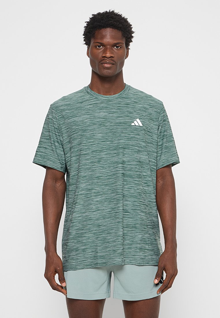 Camiseta deportiva verde jaspeada hecha de un tejido transpirable, con un escote redondo y un pequeño logo blanco de Adidas en el pecho.