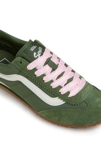 Sneaker verde realizzata in suede e tela, con lacci rosa, una striscia laterale bianca e una suola in gomma marrone. Logo sulla linguetta.