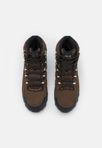 Bottes de randonnée marron avec une tige en daim et en mesh, accents texturés, œillets en métal et semelle en caoutchouc noir. Lacets réglables pour un ajustement parfait.