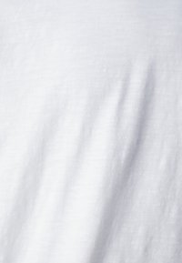 Tecido de algodão branco com uma textura suave e ligeiro brilho, exibindo linhas verticais subtis e vincos suaves.