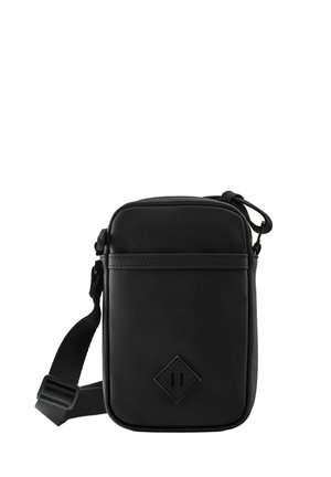 Kleine zwarte crossbodytas met verstelbare band, ritssluiting bovenaan en een diamantvormige logopatch aan de voorkant.